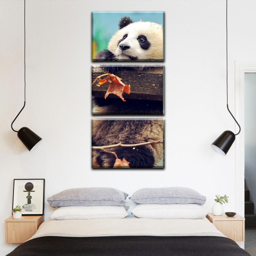 Изображение товара: Трехмодульная вертикальная картина на холсте. Игривая панда весит на бруске.